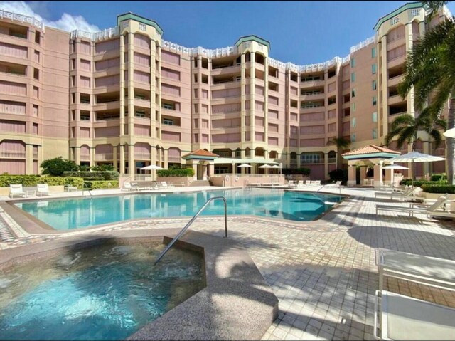 pool with a community hot tub and a patio