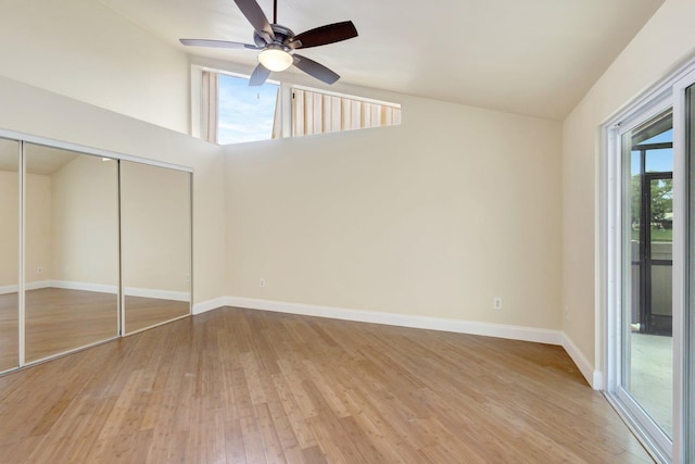 unfurnished bedroom with baseboards, a ceiling fan, lofted ceiling, light wood-type flooring, and a closet