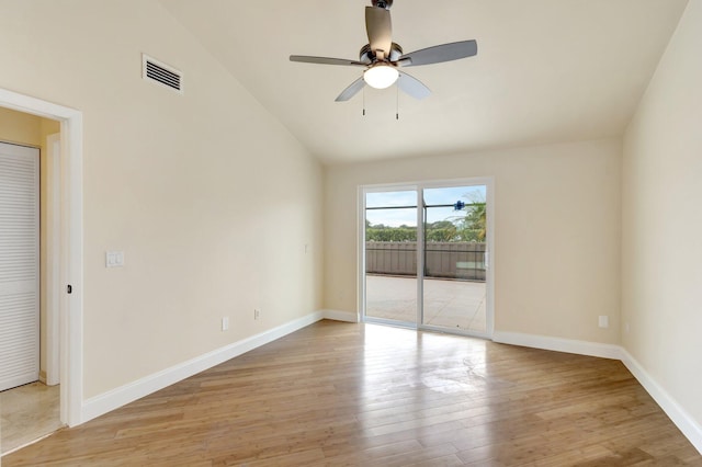 empty room with baseboards, visible vents, a ceiling fan, lofted ceiling, and light wood-style floors