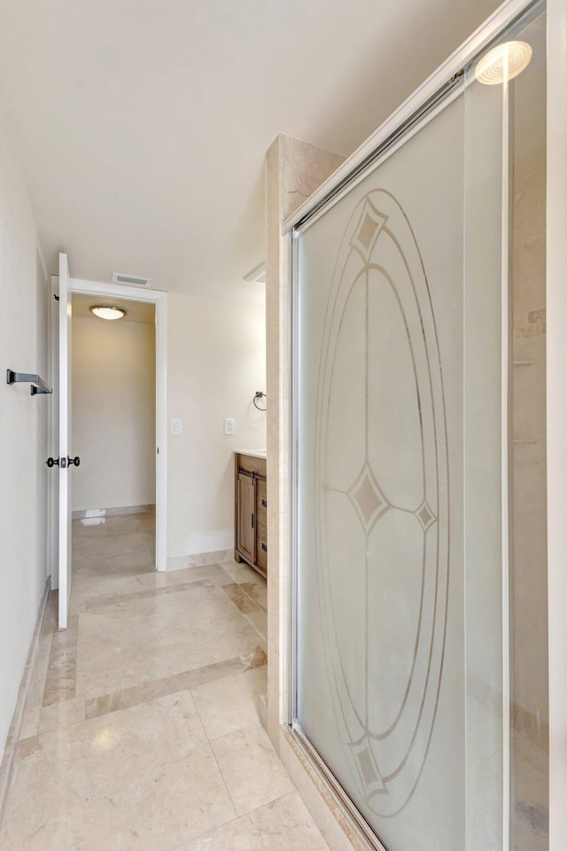 full bathroom featuring a stall shower, baseboards, visible vents, and vanity