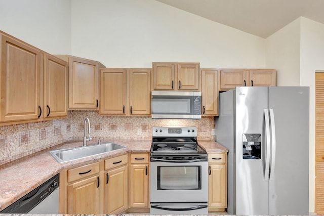 kitchen with light brown cabinets, appliances with stainless steel finishes, and a sink