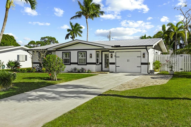 view of front of home with a front lawn, fence, concrete driveway, stucco siding, and a garage