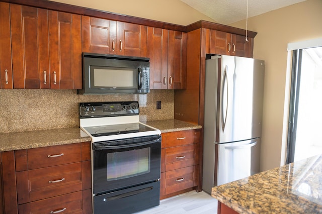 kitchen featuring decorative backsplash, electric range oven, freestanding refrigerator, light stone countertops, and black microwave