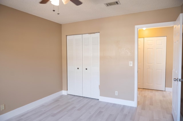 unfurnished bedroom with light wood-style floors, baseboards, visible vents, and a closet