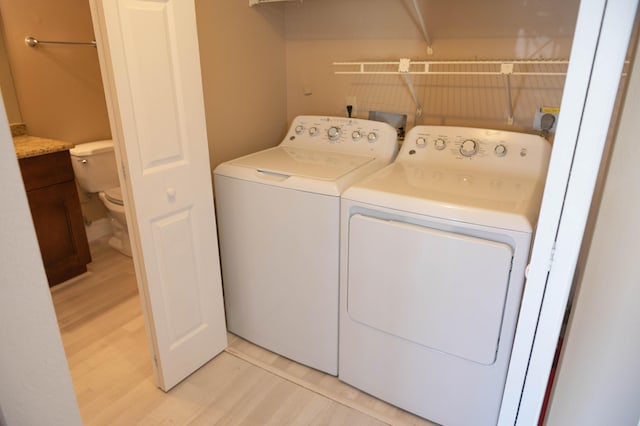 laundry area with light wood-style floors, laundry area, and washing machine and clothes dryer