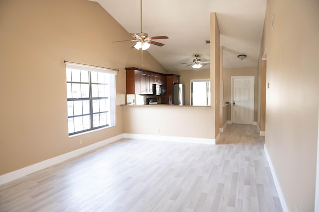 unfurnished living room featuring high vaulted ceiling, light wood finished floors, baseboards, and a ceiling fan