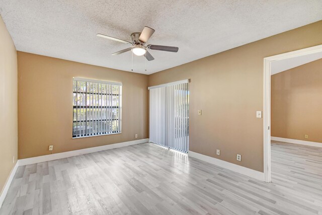 kitchen with freestanding refrigerator, high vaulted ceiling, light wood-type flooring, black microwave, and baseboards