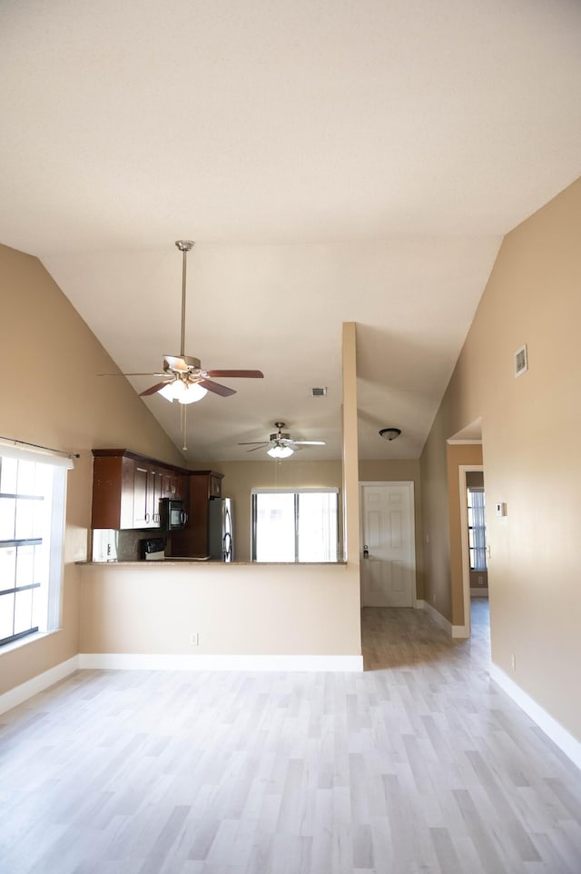 unfurnished living room featuring high vaulted ceiling, light wood-type flooring, visible vents, and baseboards