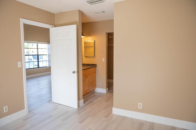 interior space featuring light wood-type flooring, visible vents, and baseboards