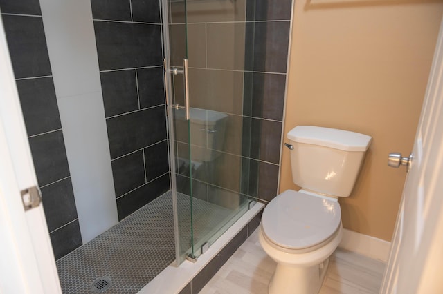 bathroom featuring a stall shower and toilet