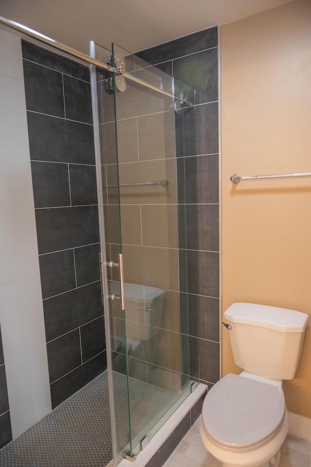 bathroom with a shower stall and toilet