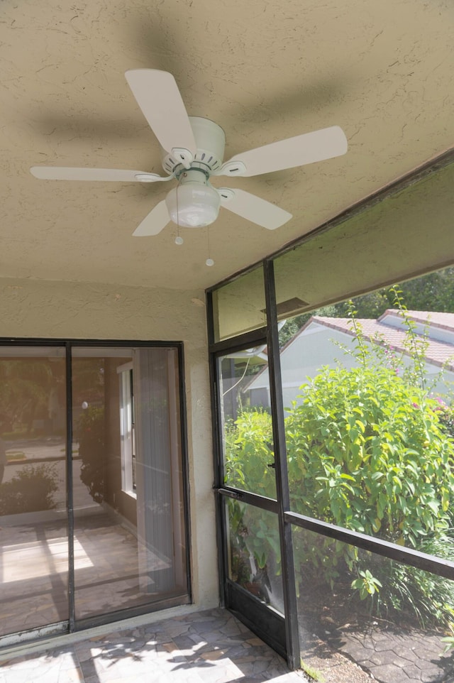 unfurnished sunroom with a wealth of natural light and a ceiling fan