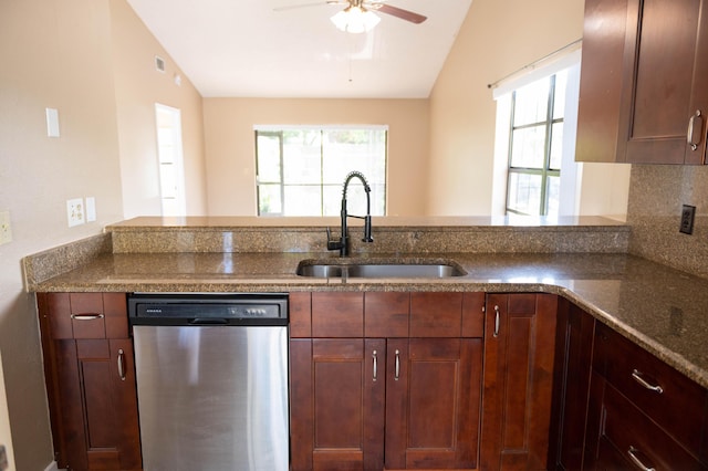 kitchen featuring plenty of natural light, dark stone counters, a sink, and stainless steel dishwasher