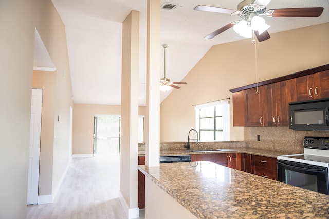 kitchen featuring stone countertops, a sink, visible vents, vaulted ceiling, and black appliances