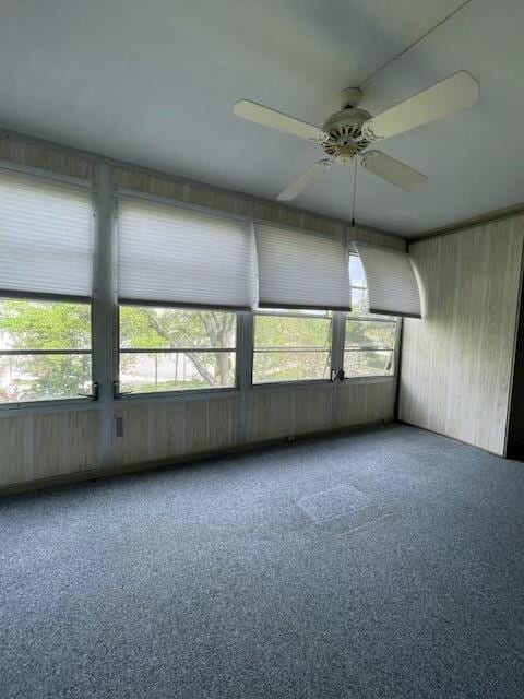 unfurnished sunroom featuring ceiling fan