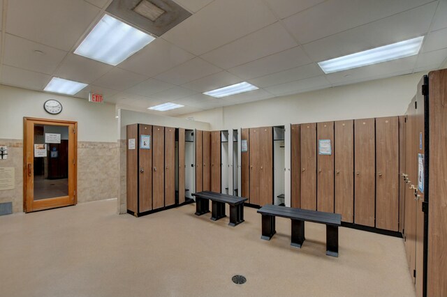 exercise room with baseboards, visible vents, and a drop ceiling