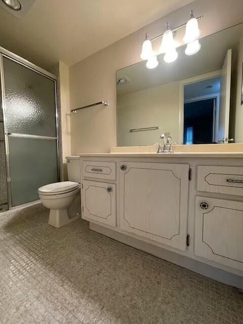 full bath with vanity, a shower stall, and toilet