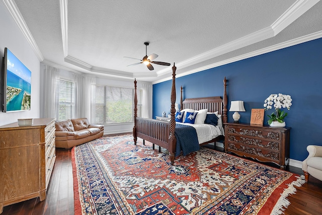 bedroom featuring a textured ceiling, ornamental molding, a raised ceiling, and dark wood-type flooring