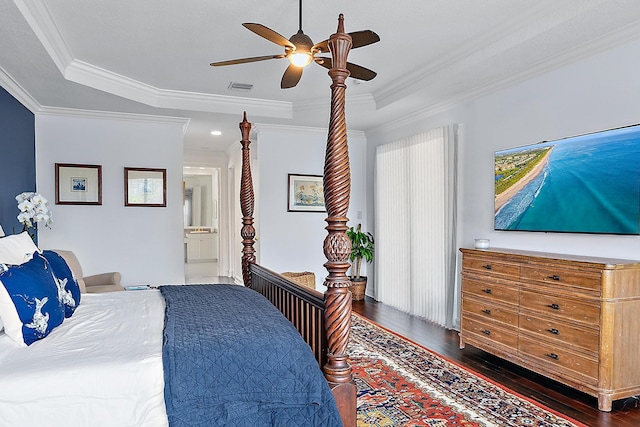 bedroom featuring hardwood / wood-style flooring, visible vents, a raised ceiling, and ornamental molding