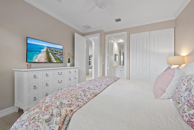 bedroom featuring visible vents, connected bathroom, ornamental molding, and a closet