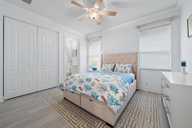 bedroom with a ceiling fan, baseboards, a closet, light wood finished floors, and crown molding