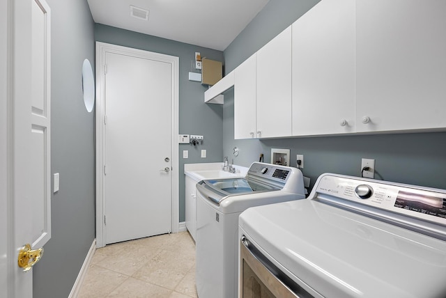 clothes washing area featuring a sink, visible vents, baseboards, cabinet space, and washer and clothes dryer