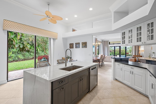 kitchen featuring white cabinets, glass insert cabinets, ornamental molding, stainless steel dishwasher, and a sink