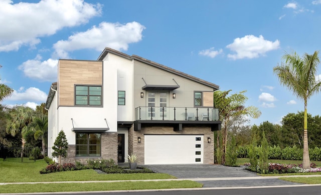 contemporary home with aphalt driveway, a balcony, a garage, stone siding, and a front lawn