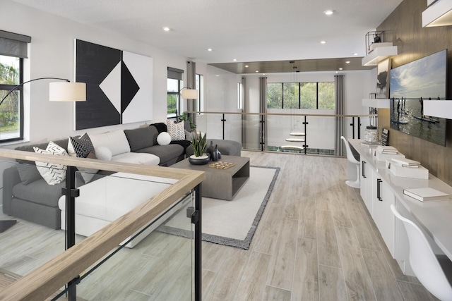 living area with light wood finished floors, plenty of natural light, and recessed lighting