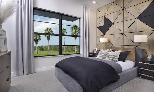 carpeted bedroom with an accent wall, recessed lighting, and baseboards