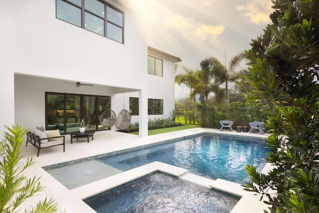 outdoor pool with an in ground hot tub, a patio, and a ceiling fan