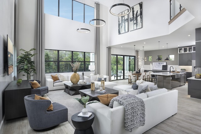 living room with light wood-style flooring and a high ceiling