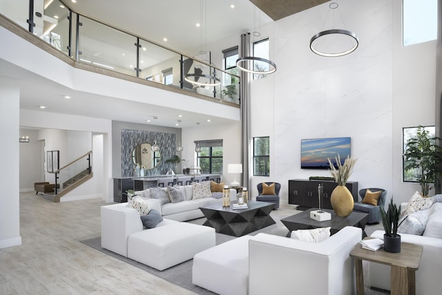 living room with recessed lighting, stairway, a towering ceiling, and wood finished floors