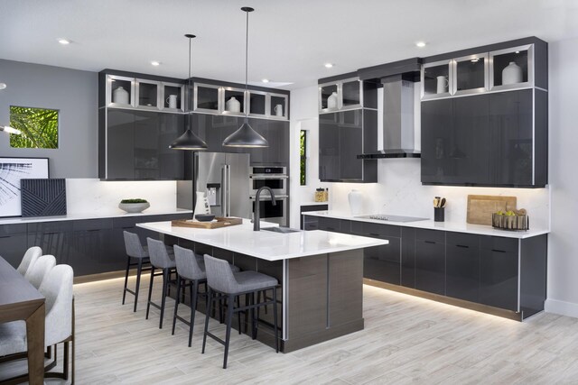 kitchen with stainless steel appliances, wall chimney exhaust hood, modern cabinets, and dark cabinets