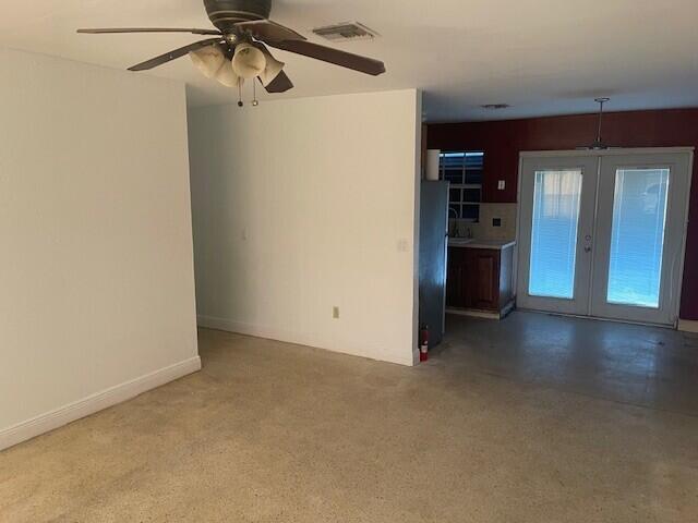 unfurnished living room featuring a ceiling fan, french doors, visible vents, and baseboards