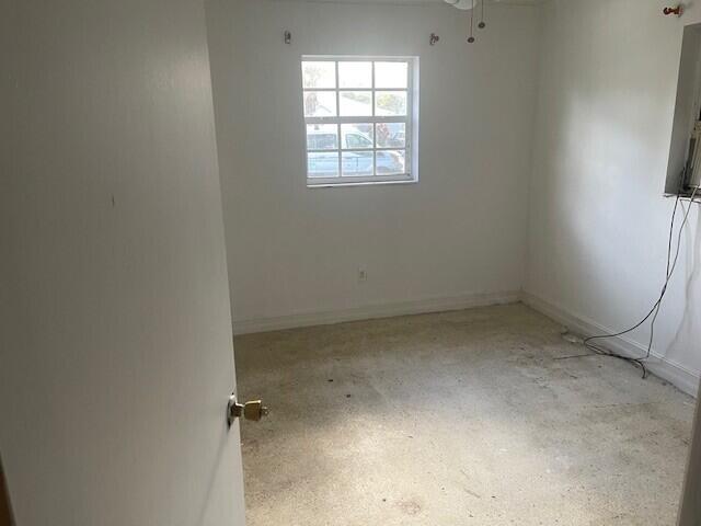 spare room with ceiling fan and baseboards