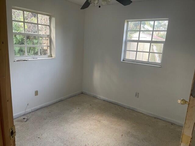 spare room with a ceiling fan, baseboards, and speckled floor