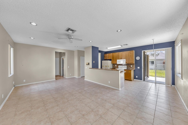 kitchen featuring white appliances, tasteful backsplash, visible vents, open floor plan, and ceiling fan with notable chandelier