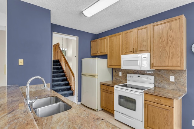 kitchen featuring light tile patterned flooring, white appliances, a sink, light countertops, and decorative backsplash