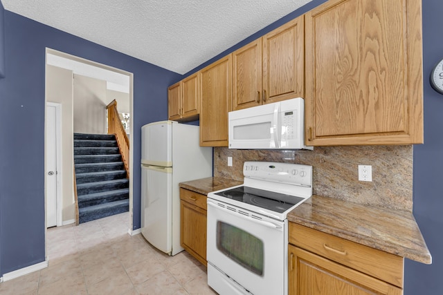 kitchen with white appliances, tasteful backsplash, baseboards, a textured ceiling, and light tile patterned flooring