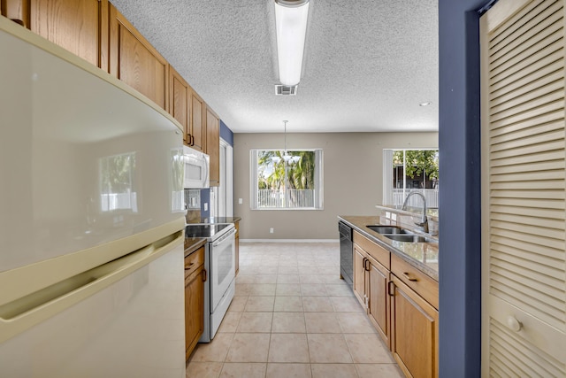 kitchen featuring white appliances, brown cabinetry, light tile patterned flooring, and a sink