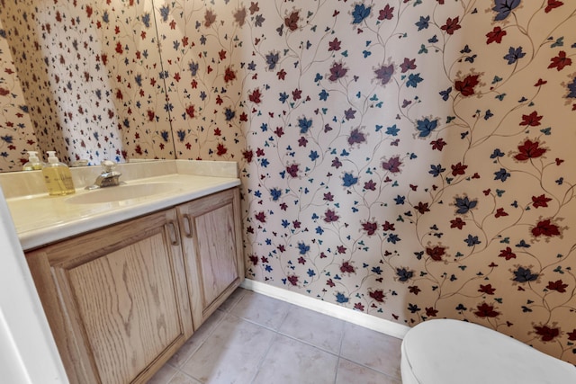 bathroom with toilet, wallpapered walls, tile patterned flooring, and vanity