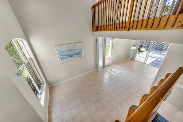 entryway featuring a towering ceiling and baseboards