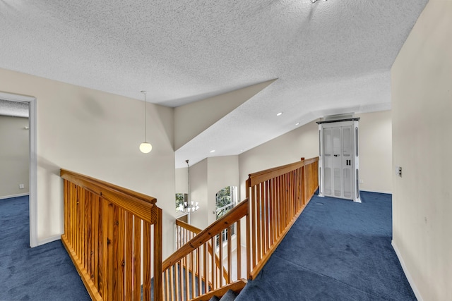 corridor with vaulted ceiling, carpet, an upstairs landing, and baseboards