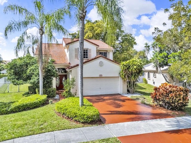 mediterranean / spanish house with stucco siding, a garage, driveway, a tiled roof, and a front lawn