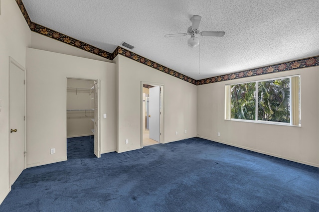 unfurnished bedroom featuring vaulted ceiling, carpet floors, and visible vents