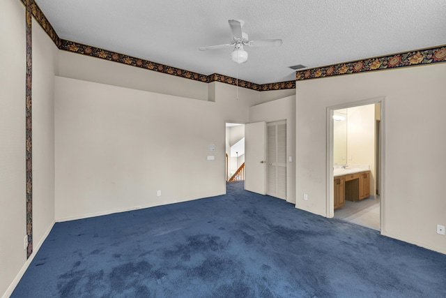 interior space with a textured ceiling, ceiling fan, and visible vents