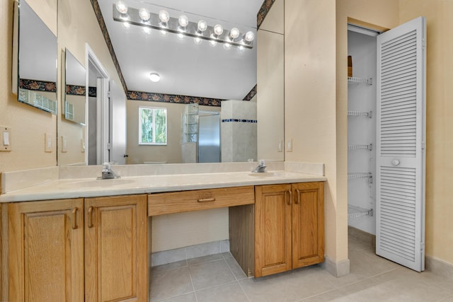 full bathroom featuring double vanity, a closet, tile patterned flooring, and a sink