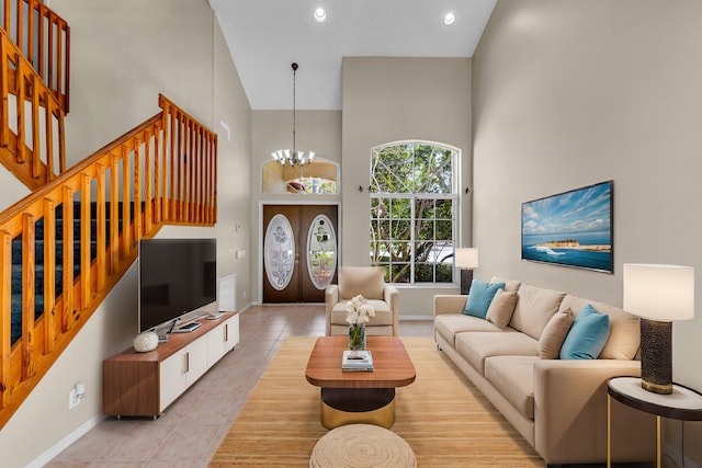 living area with stairs, light tile patterned floors, a towering ceiling, and a notable chandelier