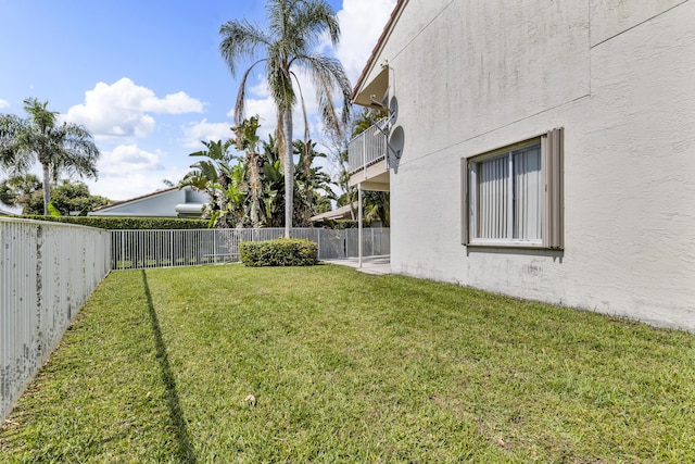 view of yard featuring a balcony and a fenced backyard